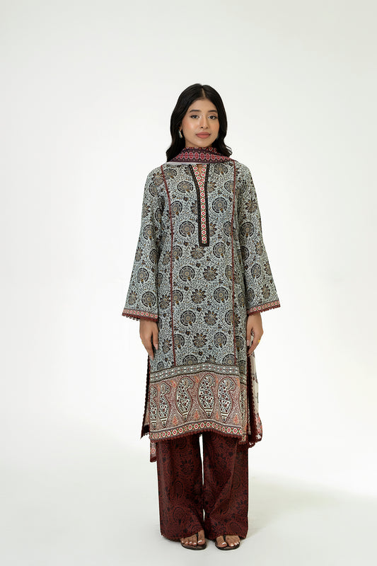 Woman wearing a patterned kurta with brown pants on a white background