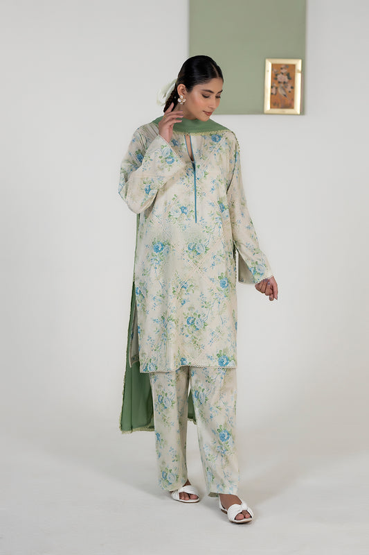 Woman wearing a floral outfit with a green dupatta against a white background