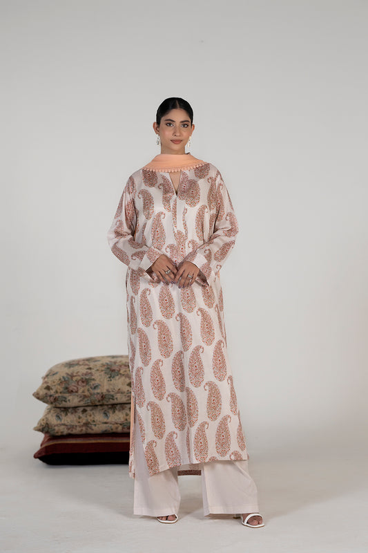 Woman wearing a patterned kurta with matching pants against a plain background