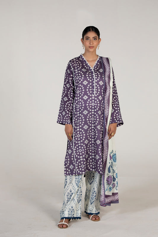Woman wearing a purple patterned outfit with a white background