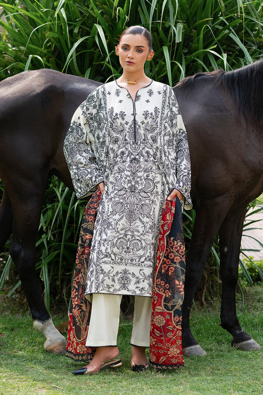 A woman standing in front of a horse, wearing a white and black embroidered ensemble with a multicolored chiffon dupatta.