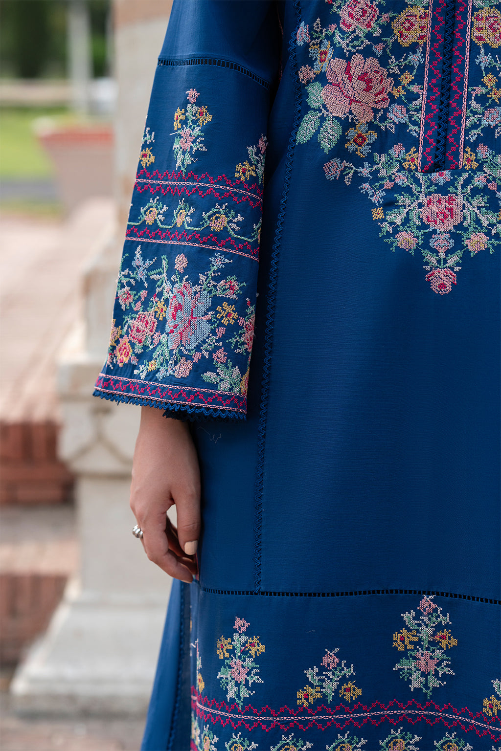Blue garment with floral embroidery details.