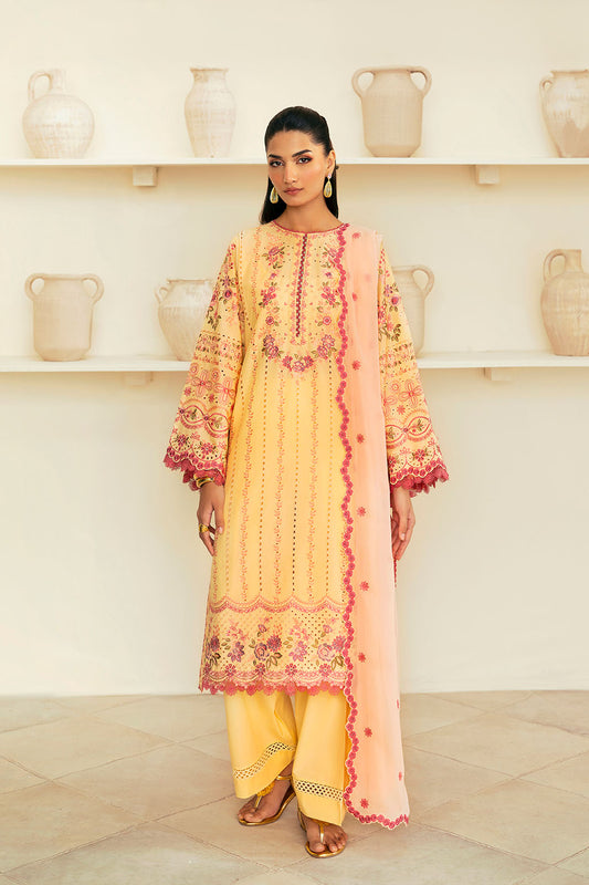 A woman wearing a traditional yellow dress with intricate embroidery and a chiffon dupatta.
