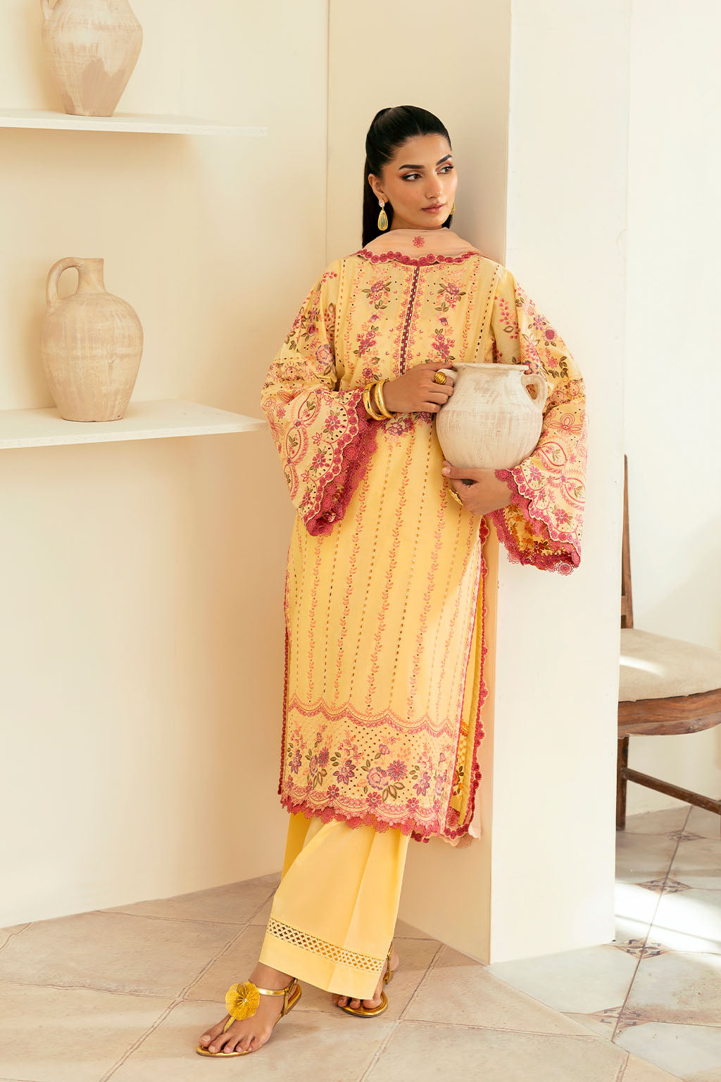 woman wearing a traditional yellow dress with intricate embroidery and wearing dupatta full view