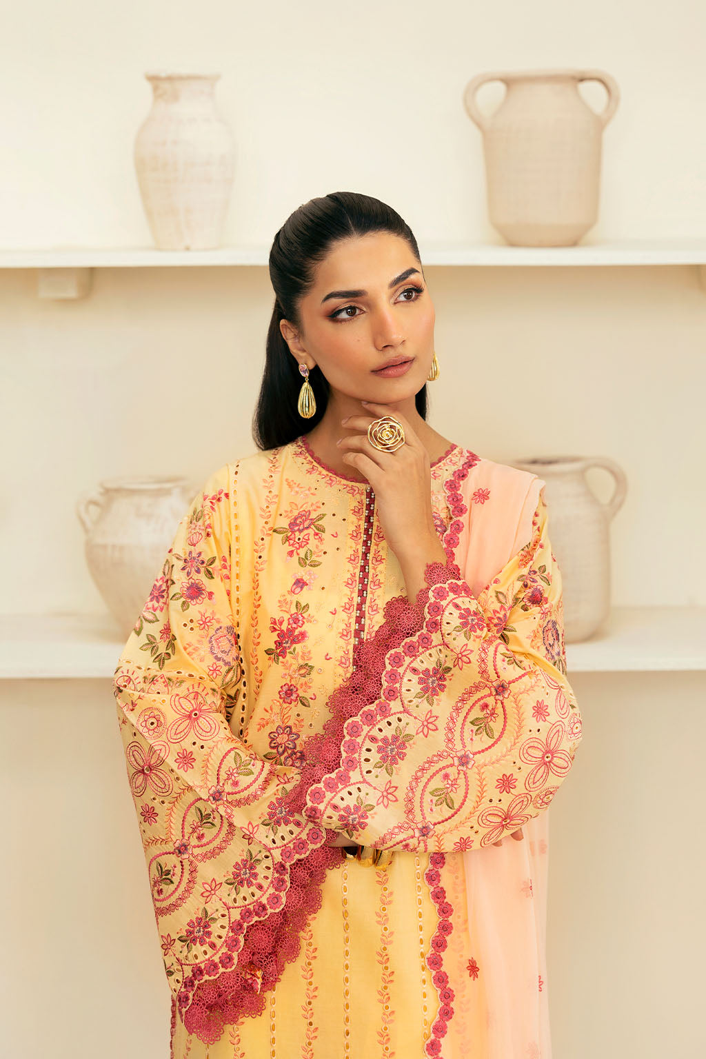 woman wearing a traditional yellow dress with intricate embroidery on Arms 