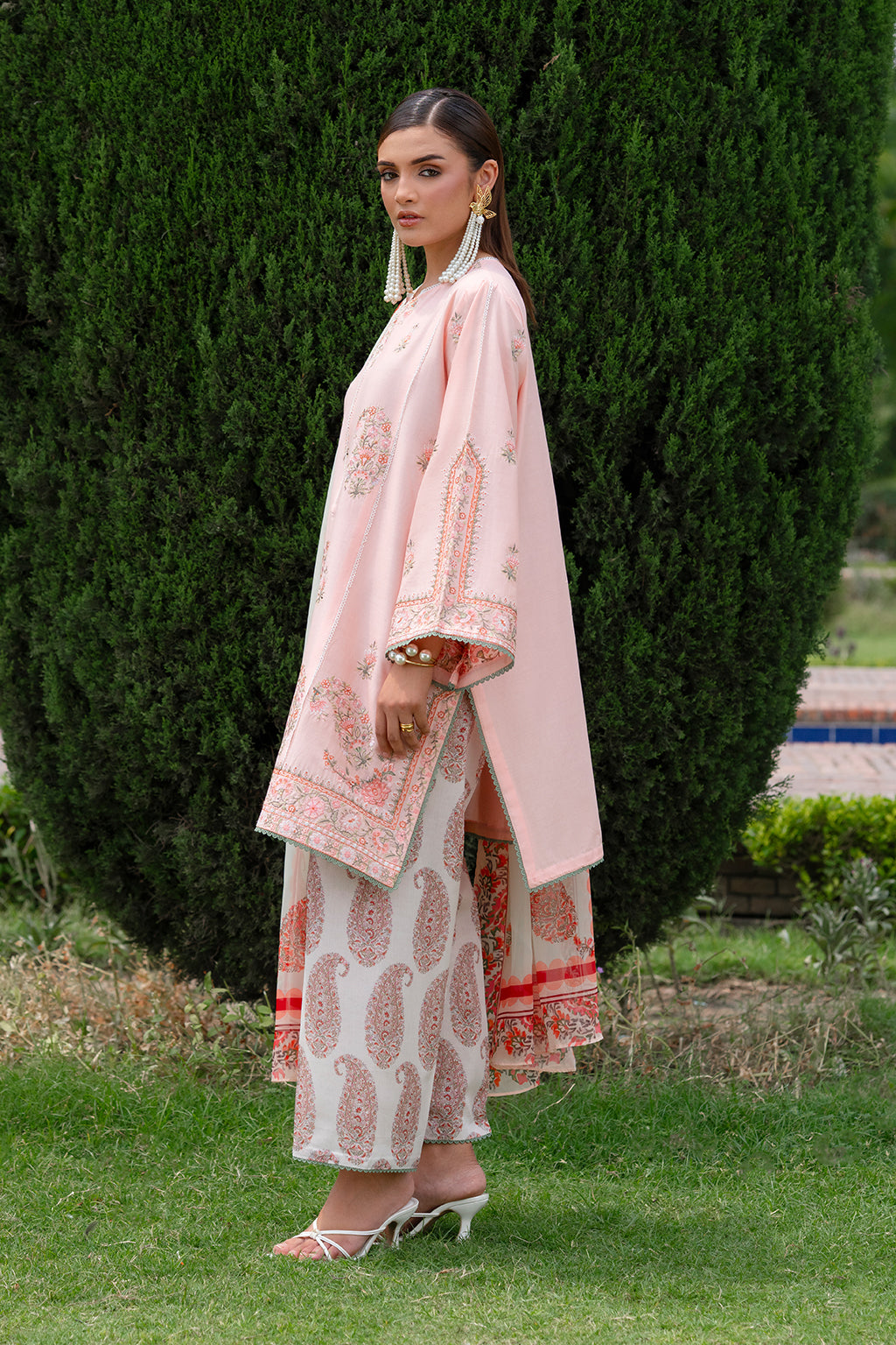 Woman in a traditional outfit standing in a garden